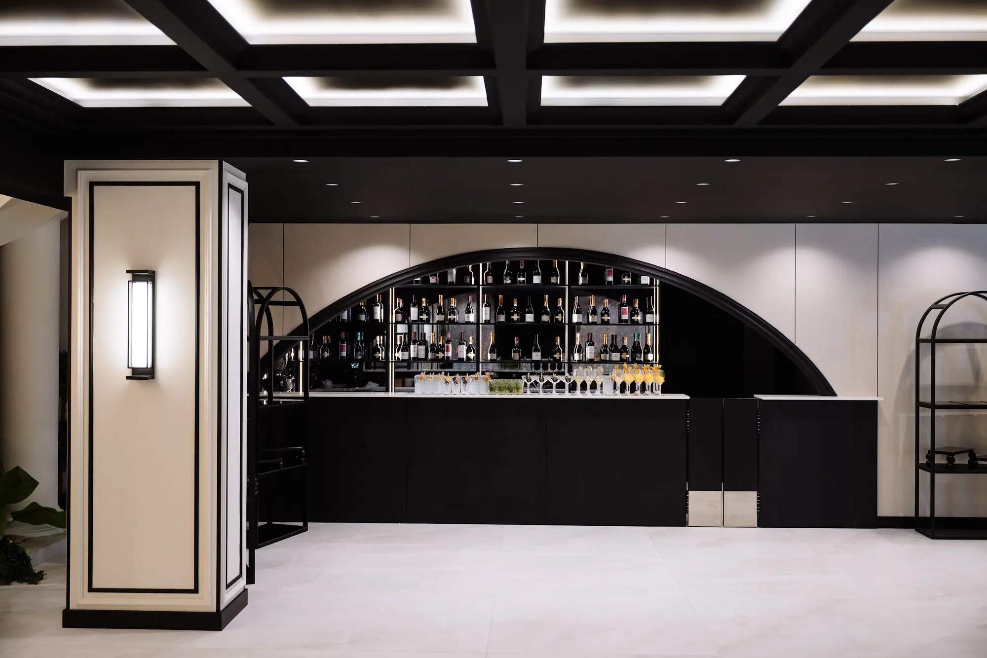 Foaierul negru al sălii Noir, cu scară, plante și bar sub arcadă