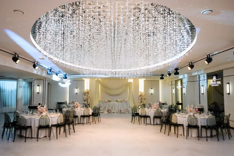 Sala Noir sub candelabrul rotund de cristal, cu mese rotunde și scaune transparente