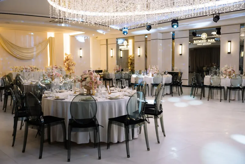 Sala Noir sub candelabrul rotund de cristal, cu mese rotunde și scaune transparente