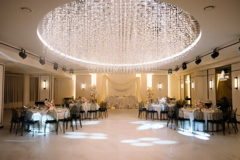 Sala Noir sub candelabrul rotund de cristal, cu mese rotunde și scaune transparente