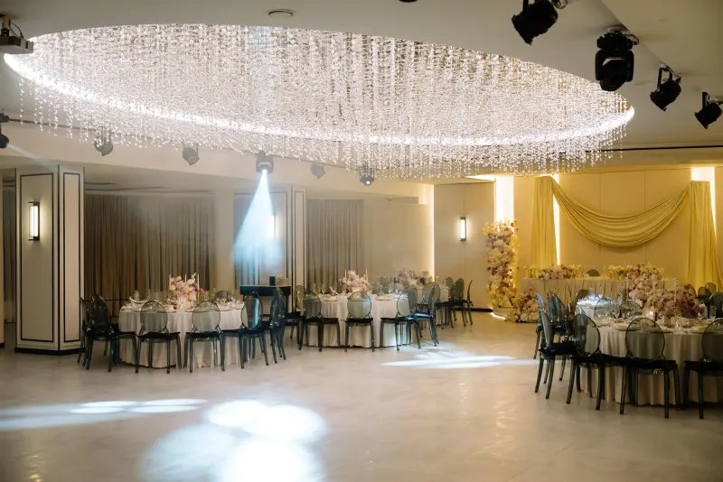 Sala Noir sub candelabrul rotund de cristal, cu mese rotunde și scaune transparente