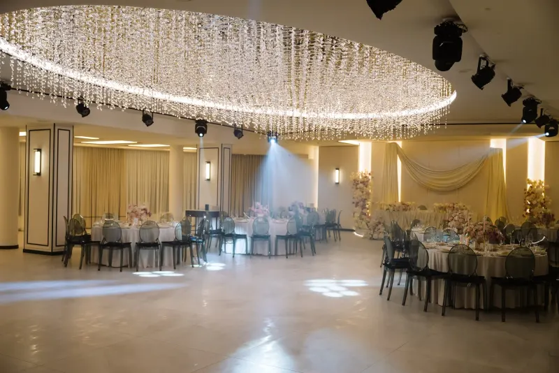 Sala Noir sub candelabrul rotund de cristal, cu mese rotunde și scaune transparente