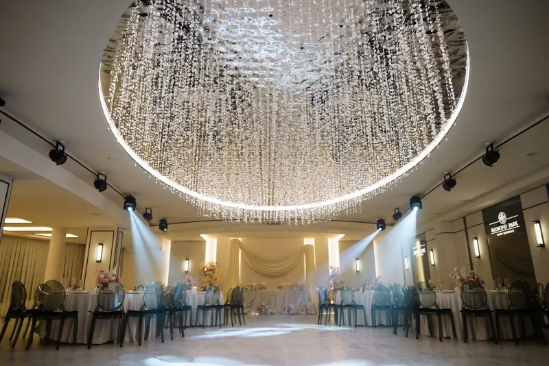 Sala Noir sub candelabrul rotund de cristal, cu mese rotunde și scaune transparente