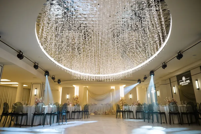 Sala Noir sub candelabrul rotund de cristal, cu mese rotunde și scaune transparente
