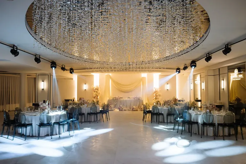 Sala Noir sub candelabrul rotund de cristal, cu mese rotunde și scaune transparente