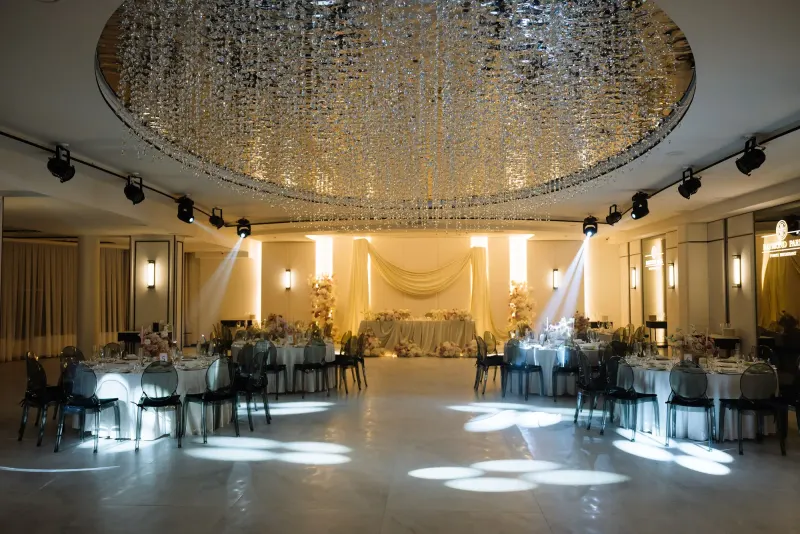 Sala Noir sub candelabrul rotund de cristal, cu mese rotunde și scaune transparente