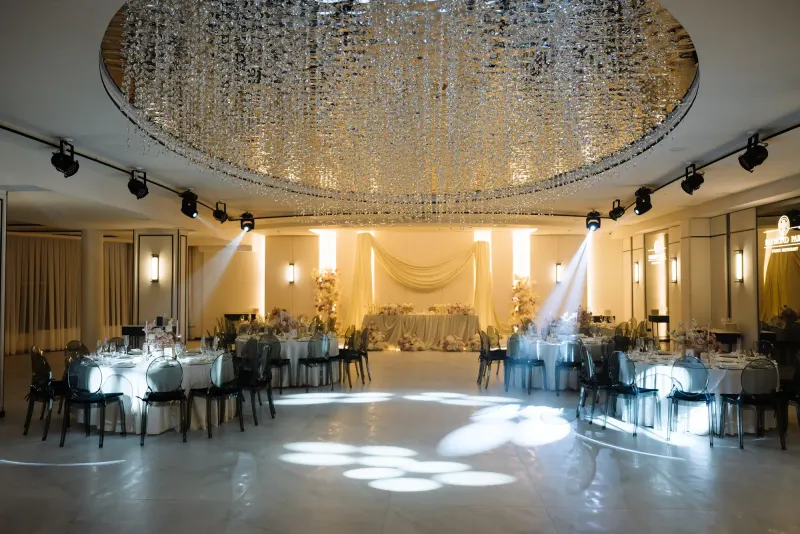Sala Noir sub candelabrul rotund de cristal, cu mese rotunde și scaune transparente