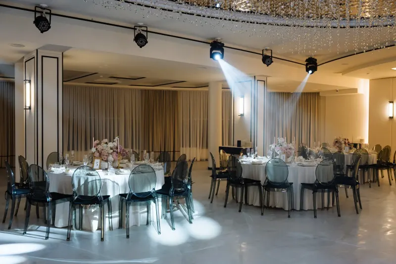 Sala Noir sub candelabrul rotund de cristal, cu mese rotunde și scaune transparente