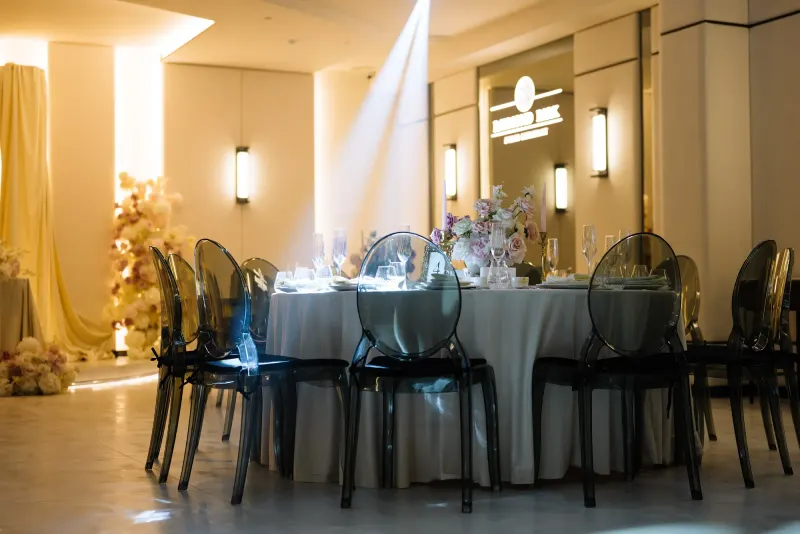 Sala Noir sub candelabrul rotund de cristal, cu mese rotunde și scaune transparente