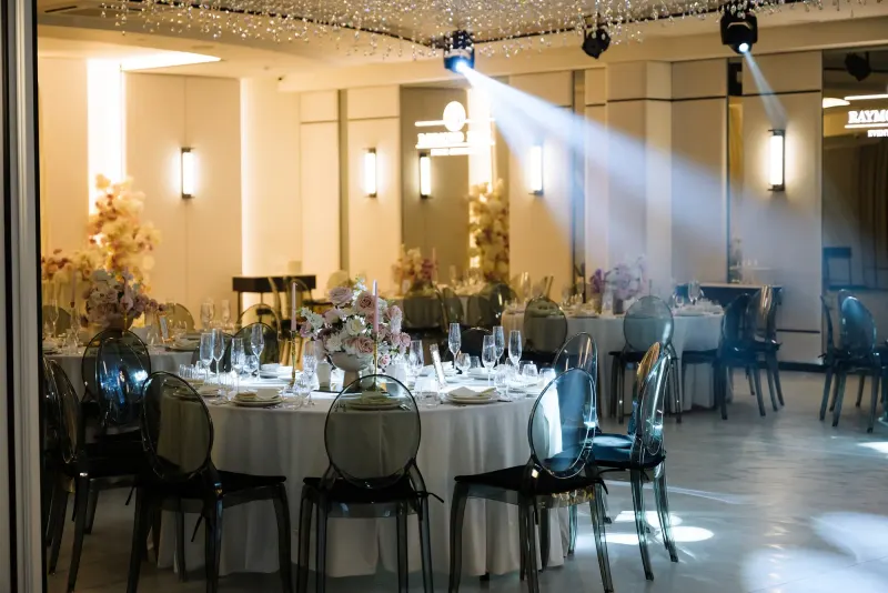 Sala Noir sub candelabrul rotund de cristal, cu mese rotunde și scaune transparente