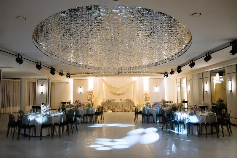 Sala Noir sub candelabrul rotund de cristal, cu mese rotunde și scaune transparente
