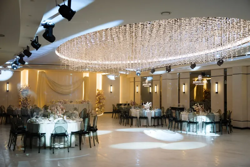 Sala Noir sub candelabrul rotund de cristal, cu mese rotunde și scaune transparente