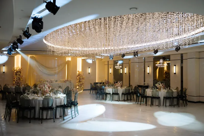 Sala Noir sub candelabrul rotund de cristal, cu mese rotunde și scaune transparente