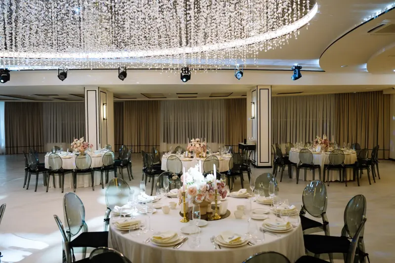 Sala Noir sub candelabrul rotund de cristal, cu mese rotunde și scaune transparente