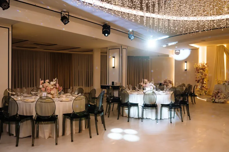 Sala Noir sub candelabrul rotund de cristal, cu mese rotunde și scaune transparente