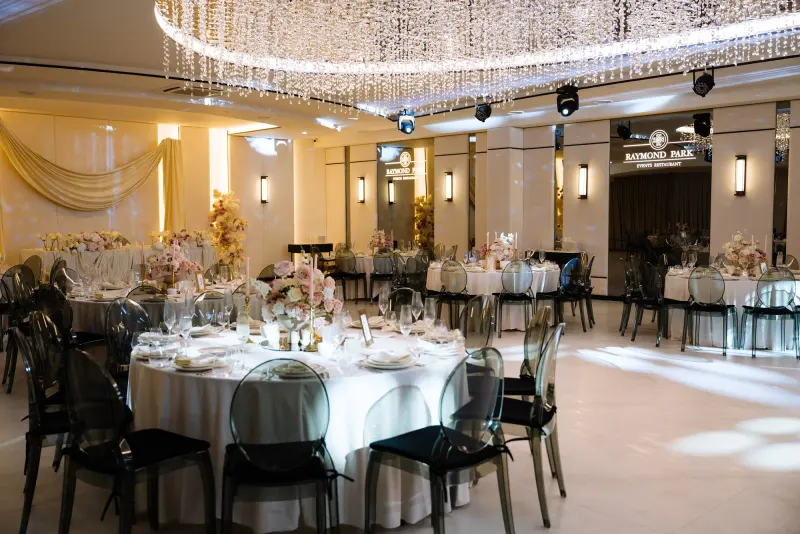 Sala Noir sub candelabrul rotund de cristal, cu mese rotunde și scaune transparente